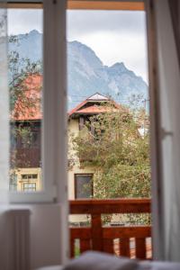 a window view of a building with mountains in the background at Casa Bucegi Busteni in Buşteni