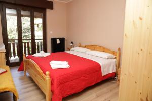 una camera da letto con un letto rosso e asciugamani di Casa Vacanze Limone a Limone Piemonte