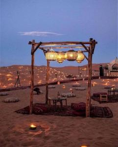 a wooden arch with lights in the desert at The Desert Safari Jaisalmer in Sām