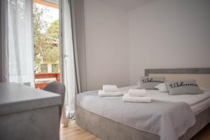 una camera da letto con un letto con lenzuola bianche e una finestra di Casa Bucegi Busteni a Buşteni