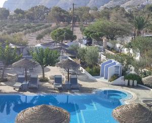 a pool with chairs and umbrellas in a resort at HOTEL MOHITERO in Kamari