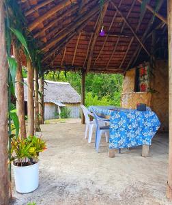 eine Terrasse mit einem Tisch und Stühlen in einem Pavillon in der Unterkunft Imaio home stay in Ipenyen