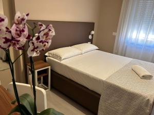 um quarto com uma cama e um vaso com flores em Villa Angeli em Roma