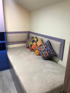 a bed with colorful pillows on it in a room at Luxury,2 level penthouse in Tsakhkadzor in Tsaghkadzor