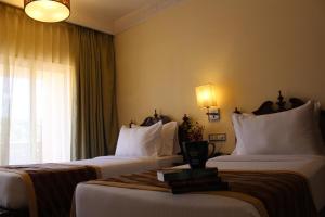 Habitación de hotel con 2 camas y ventana en Evershine Resort & Spa, en Mahabaleshwar