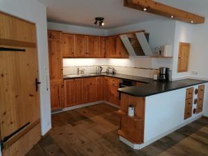 a kitchen with wooden cabinets and a black counter top at Ferienhaus Region Tegernsee in Miesbach