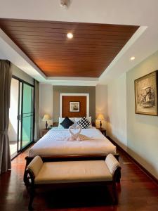 1 dormitorio con 1 cama grande y techo de madera en Yotaka Bangkok Hotel, en Bangkok