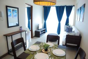 a dining table and chairs in a living room at L'eau Bleue Boracay Condotel in Boracay