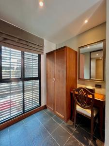 una oficina con escritorio de madera y ventana en Yotaka Bangkok Hotel, en Bangkok