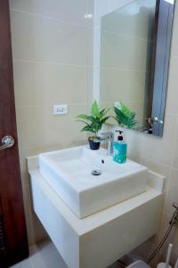 a bathroom with a white sink and a mirror at L'eau Bleue Boracay Condotel in Boracay