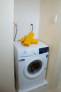 a washing machine with yellow towels on top of it at L'eau Bleue Boracay Condotel in Boracay