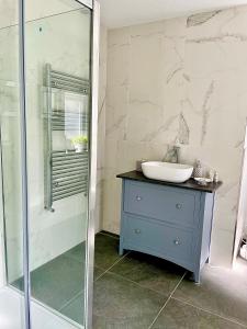 bagno con lavandino e doccia in vetro di Stables riverside cottage Ambleside ad Ambleside