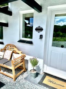 una veranda con panca di legno accanto a una porta di Stables riverside cottage Ambleside ad Ambleside
