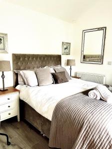 una camera con un grande letto e uno specchio di Stables riverside cottage Ambleside ad Ambleside
