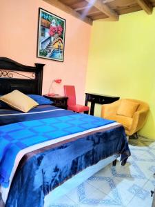 um quarto com uma cama e uma cadeira em Hotel Casa Tecpán em Pamanzana