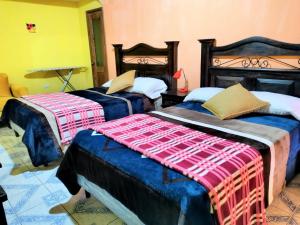a room with two beds with blankets on them at Hotel Casa Tecpán in Pamanzana