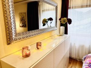 a white dresser with a mirror and flowers on it at Natal Gian in Ischgl