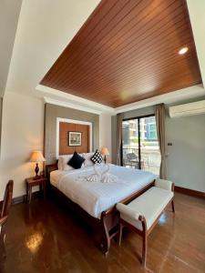 1 dormitorio con 1 cama grande y techo de madera en Yotaka Bangkok Hotel, en Bangkok