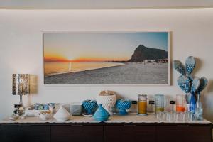 un tavolo con vasi blu e un'immagine su un muro di Hotel Piccolo Mondo a San Vito lo Capo