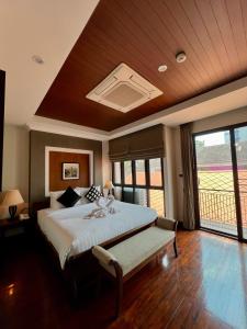 1 dormitorio con cama grande y ventana grande en Yotaka Bangkok Hotel, en Bangkok