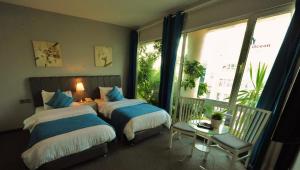 um quarto com 2 camas e uma grande janela em The Conroy Boutique Hotel em Amã