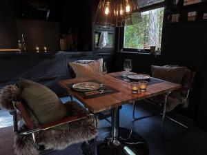 una mesa de madera con sillas y copas de vino. en The Lodge, en Mölnlycke