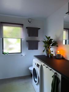 lavadero con lavadora y ventana en The Lodge, en Mölnlycke