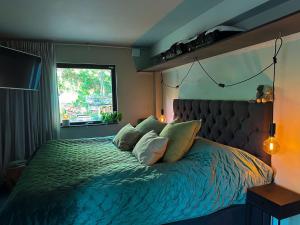 1 dormitorio con cama con almohadas y ventana en The Lodge, en Mölnlycke