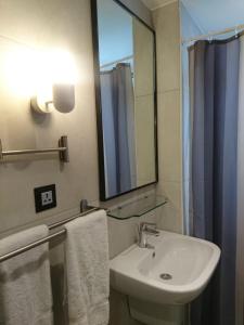 a bathroom with a sink and a mirror and towels at The Conroy Boutique Hotel in Amman