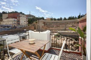 ein Balkon mit Tisch und Stühlen auf einem Dach in der Unterkunft Casa Terma del Teatro in Cartagena