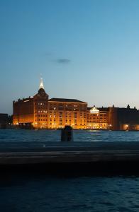 um grande edifício à noite com a água na frente em Ca' Monica Apartment em Veneza