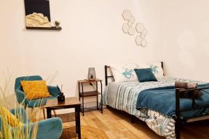 - une chambre avec un lit et une chaise dans l'établissement Le petit Cocon Bleu, à Flers