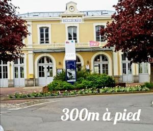 un bâtiment jaune avec un panneau devant lui dans l'établissement Le petit Cocon Bleu, à Flers