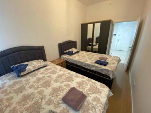 1 Schlafzimmer mit 2 Betten und einem Spiegel in der Unterkunft 3+1Apartment, City View in Basaksehir