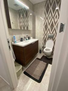 ein Badezimmer mit einem Waschbecken, einem WC und einem Spiegel in der Unterkunft 3+1Apartment, City View in Basaksehir
