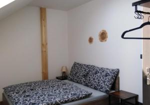 una camera da letto con un letto con una coperta bianca e nera di Apartmány Jakubov a Wickwitz