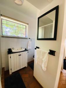 a bathroom with a sink and a mirror at The White House in Hartbeespoort