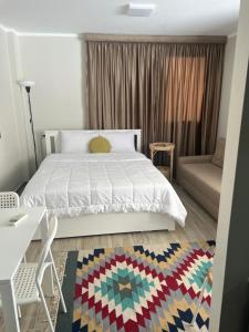 a bedroom with a white bed and a couch at Luxury stay roof top in 6th Of October