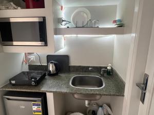 a small kitchen with a sink and a microwave at Luxury stay roof top in 6th Of October