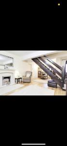 a large living room with a couch and a staircase at Dorterry House in Ilkeston