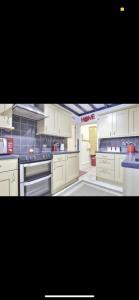 a large kitchen with white cabinets and appliances at Dorterry House in Ilkeston