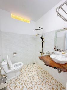 a bathroom with a toilet and a sink at Ahome in Buôn Ðũng