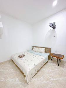 Dormitorio blanco con cama y mesa en Ahome en Buôn Ðũng