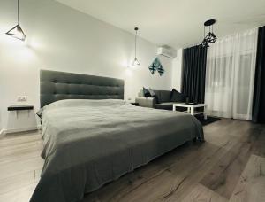 a bedroom with a large bed and a couch at Park View Studio - NETFLIX in Bucharest