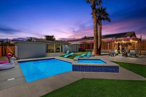 un patio trasero con piscina y una casa en New!Palm Springs Windmill Villa-Pool/Spa/Golf/View, en North Palm Springs