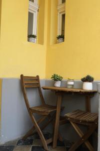 un tavolo e due sedie accanto a un muro giallo di Elegantný Art Deco byt v Banskej Bystrici a Banská Bystrica