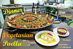 a pizza in a pan on a counter with a plate of food at La Casa Mágica in Villatuerta