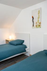 a bedroom with two beds and a painting on the wall at Gîte du héron de Sologne Calme classé 3étoiles Forêt WIFI Animaux bienvenus Services ProsConciergerie Comte des Cierges in Brinon-sur-Sauldre