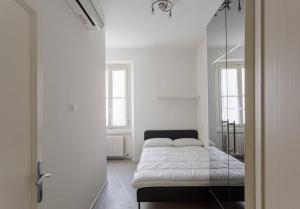 Central and Glamour home! في ميلانو: غرفة نوم بيضاء مع سرير ومرآة