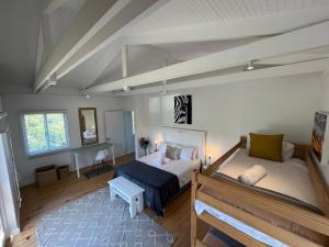 a bedroom with a bed and a bench in it at Baha Sanctuary Villa - 2 Bedroom Pool Villa in Plettenberg Bay